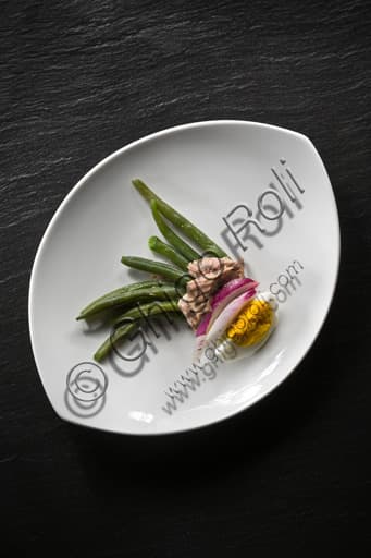 Foto di un'insalata di fagiolini e tonno con cipolla e uovo sodo in una ciotola bianca